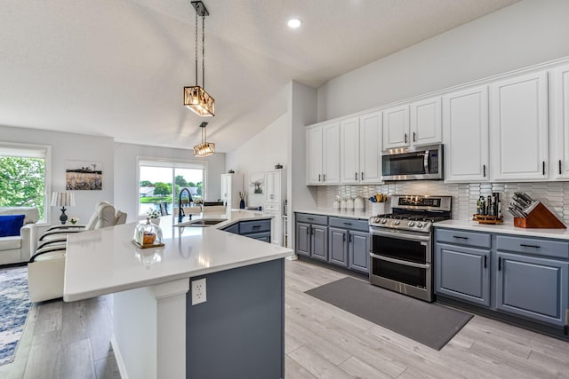 11001 Isanti Ct NE, Blaine, MN 55449 - kitchen with appliances with stainless steel finishes, a sink, gray cabinetry, vaulted ceiling, and tasteful backsplash