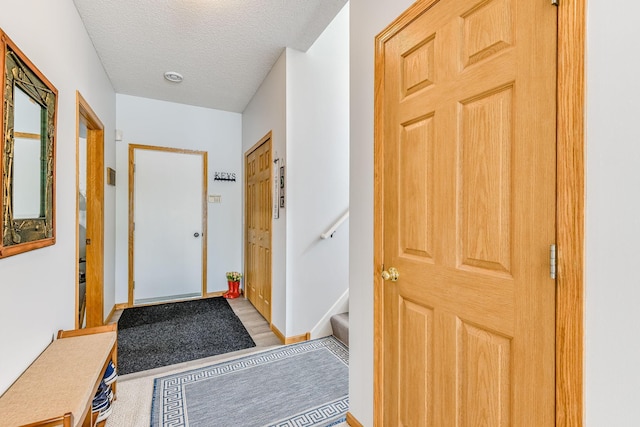11001 Isanti Ct NE, Blaine, MN 55449 - doorway featuring a textured ceiling, stairway, and baseboards