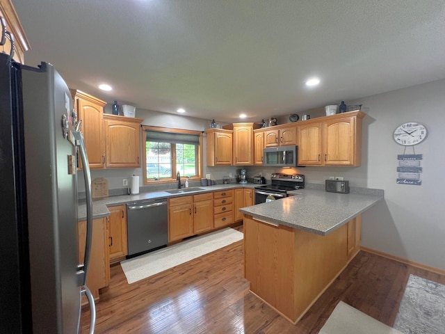 1209 23rd St SE, Willmar, MN 56201 - kitchen with appliances with stainless steel finishes, a peninsula, a sink, light wood finished floors, and recessed lighting