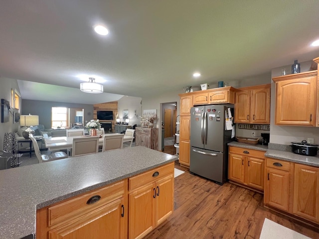 1209 23rd St SE, Willmar, MN 56201 - kitchen featuring freestanding refrigerator, light wood finished floors, recessed lighting, open floor plan, and a fireplace