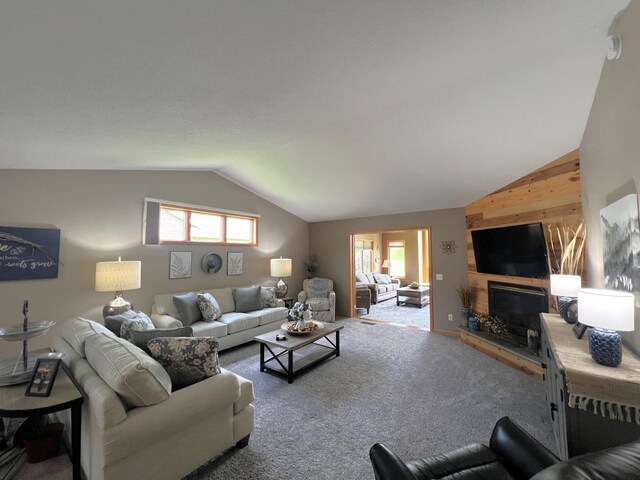 1209 23rd St SE, Willmar, MN 56201 - carpeted living room featuring lofted ceiling, healthy amount of natural light, wood walls, and a glass covered fireplace