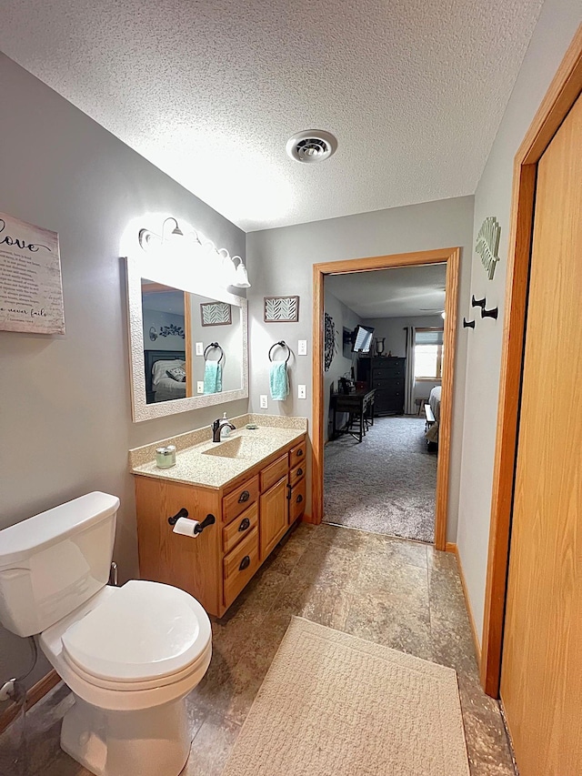 1209 23rd St SE, Willmar, MN 56201 - bathroom featuring ensuite bathroom, vanity, toilet, and a textured ceiling
