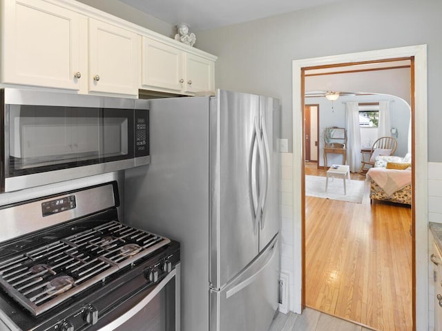 1033 Hall Ave W, Saint Paul, MN 55118 - kitchen featuring appliances with stainless steel finishes, white cabinets, and light wood finished floors