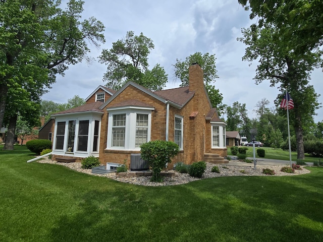 620 5th Ave SE, Pipestone, MN 56164 - rear view of house with a chimney, a yard, cooling unit, and brick siding