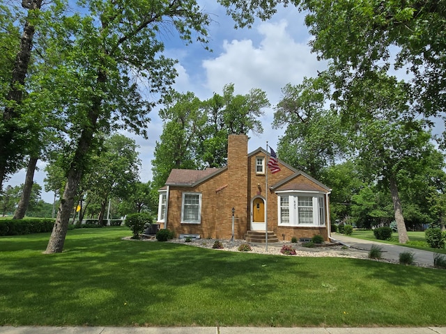 620 5th Ave SE, Pipestone, MN 56164 - view of front of property featuring a front yard, brick siding, and a chimney