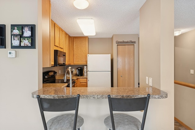 15548 Float Ln Unit 104, Apple Valley, MN 55124 - kitchen with black appliances, a textured ceiling, a peninsula, a kitchen breakfast bar, and light countertops