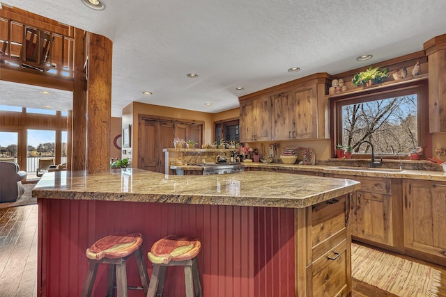 2917 Vonderheide Dr SW, Alexandria, MN 56308 - kitchen with a sink, hardwood / wood-style flooring, recessed lighting, a kitchen breakfast bar, and a peninsula