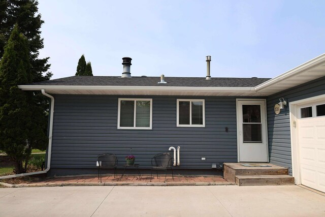 531 5th Street Ct E, West Fargo, ND 58078 - back of house featuring a garage and a shingled roof