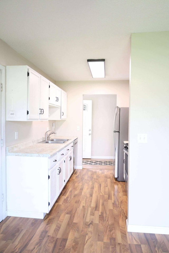 531 5th Street Ct E, West Fargo, ND 58078 - kitchen featuring a sink, stainless steel appliances, light countertops, white cabinetry, and light wood-style flooring