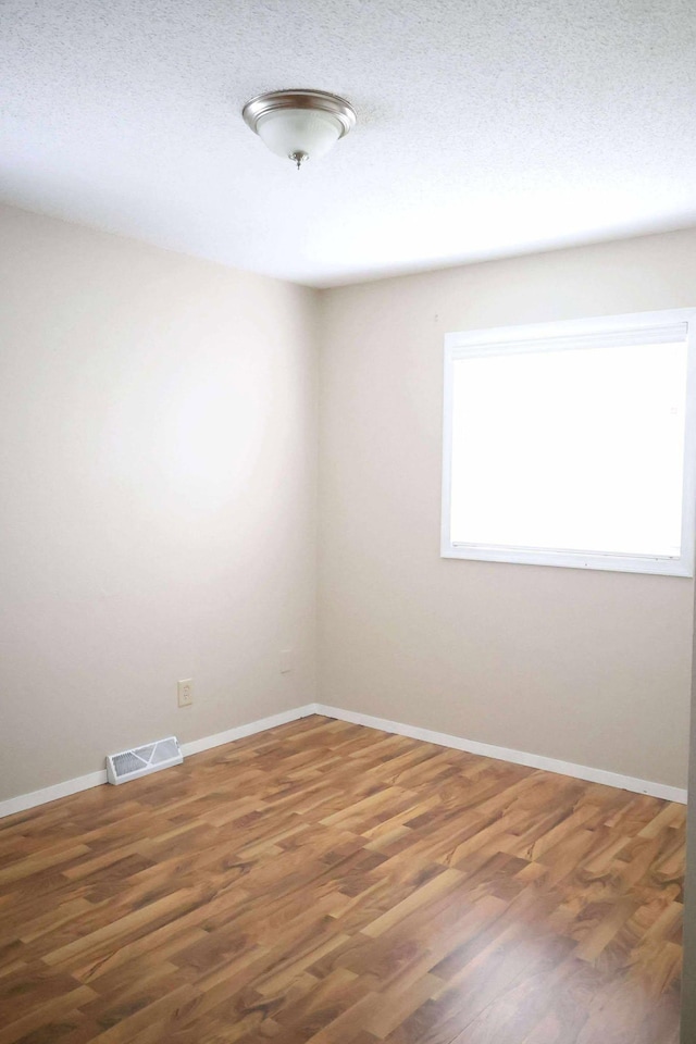 531 5th Street Ct E, West Fargo, ND 58078 - spare room with wood finished floors, baseboards, and a textured ceiling