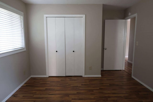 531 5th Street Ct E, West Fargo, ND 58078 - unfurnished bedroom featuring dark wood-style flooring, a closet, and baseboards