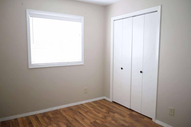 531 5th Street Ct E, West Fargo, ND 58078 - unfurnished bedroom featuring wood finished floors, a closet, and baseboards