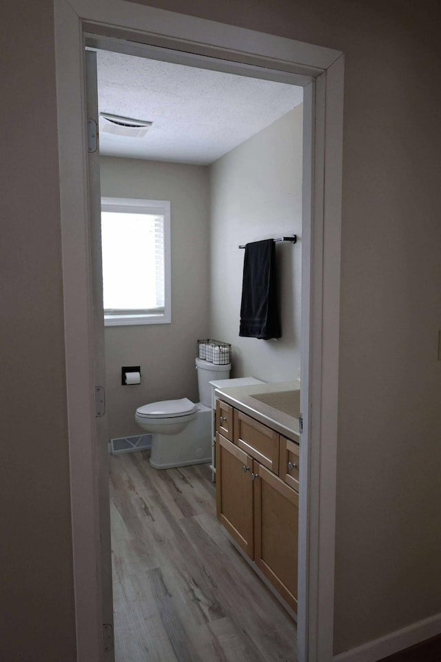531 5th Street Ct E, West Fargo, ND 58078 - bathroom featuring vanity, toilet, wood finished floors, and baseboards