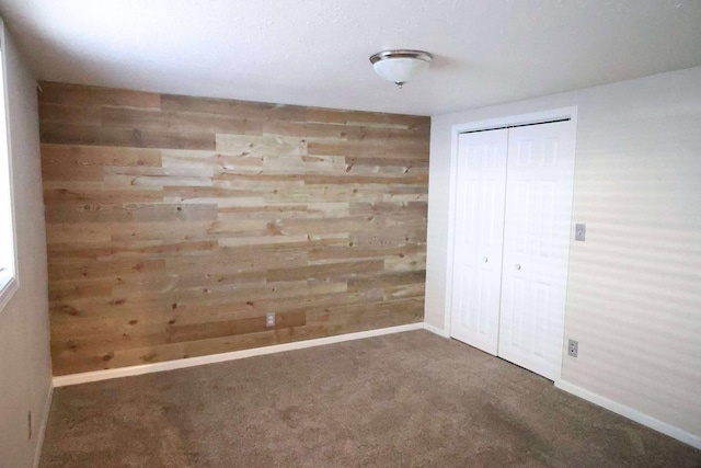 531 5th Street Ct E, West Fargo, ND 58078 - unfurnished bedroom with wooden walls, a closet, carpet, and baseboards
