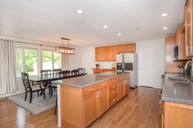 2603 140th Ln NW, Andover, MN 55304 - kitchen with stainless steel refrigerator with ice dispenser, a textured ceiling, light wood-style flooring, stove, and a center island