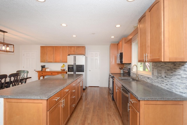 2603 140th Ln NW, Andover, MN 55304 - kitchen featuring appliances with stainless steel finishes, light wood-style flooring, a center island, recessed lighting, and decorative backsplash