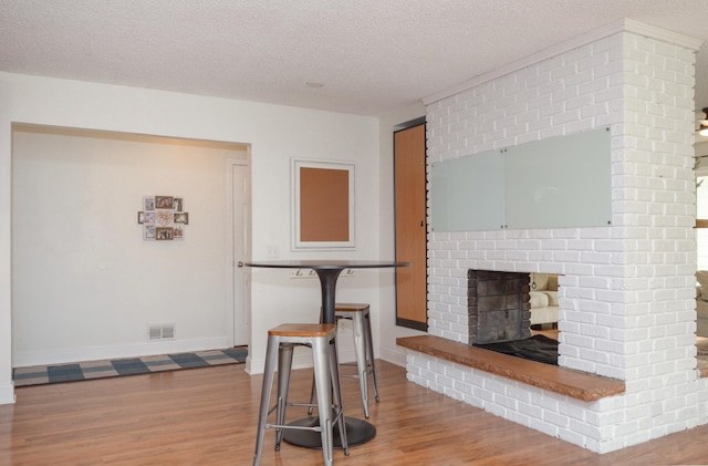 2603 140th Ln NW, Andover, MN 55304 - living area with a textured ceiling, wood finished floors, and a brick fireplace