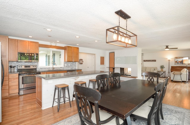 2603 140th Ln NW, Andover, MN 55304 - dining space with light wood-style flooring, a textured ceiling, recessed lighting, and a ceiling fan