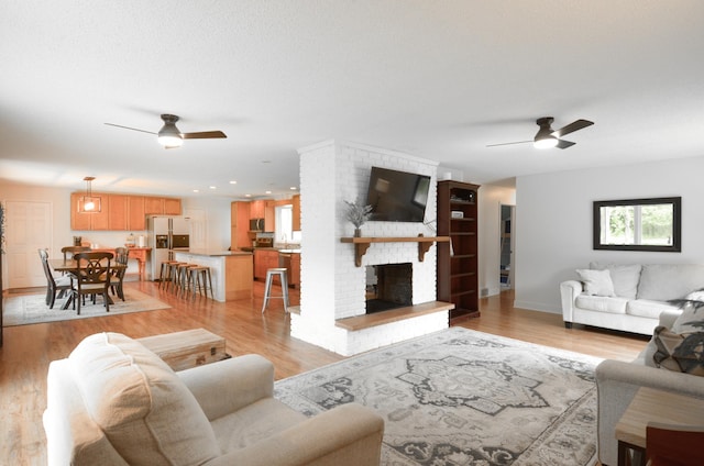 2603 140th Ln NW, Andover, MN 55304 - living area with a ceiling fan, a brick fireplace, and light wood-style floors