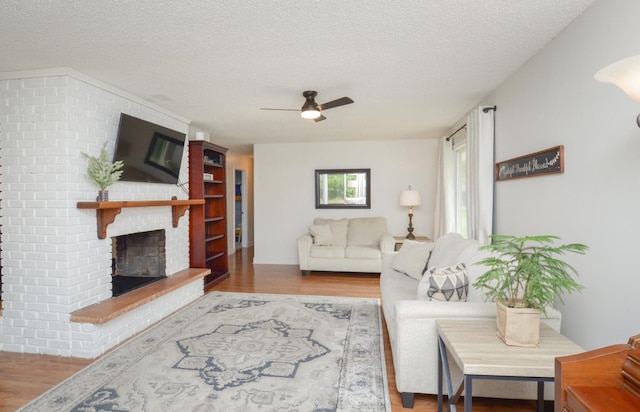 2603 140th Ln NW, Andover, MN 55304 - living area featuring a textured ceiling, wood finished floors, a fireplace, and ceiling fan