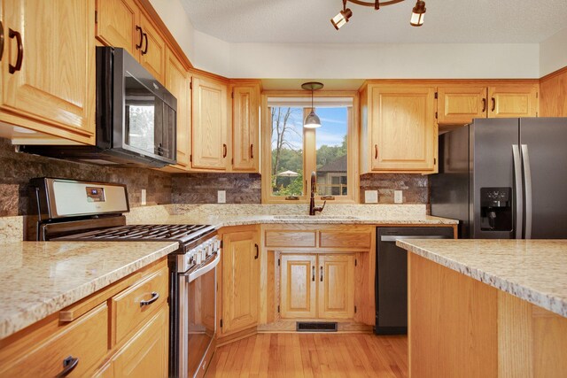 7811 209th St N, Forest Lake, MN 55025 - kitchen featuring stainless steel appliances, tasteful backsplash, light wood-style flooring, light stone counters, and light brown cabinetry