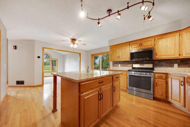 7811 209th St N, Forest Lake, MN 55025 - kitchen featuring stainless steel gas range, tasteful backsplash, and light wood-style flooring