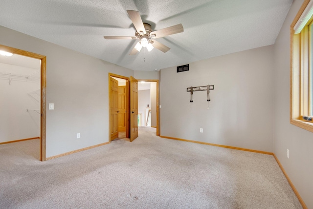 7811 209th St N, Forest Lake, MN 55025 - unfurnished bedroom featuring light colored carpet, a spacious closet, a closet, ceiling fan, and a textured ceiling