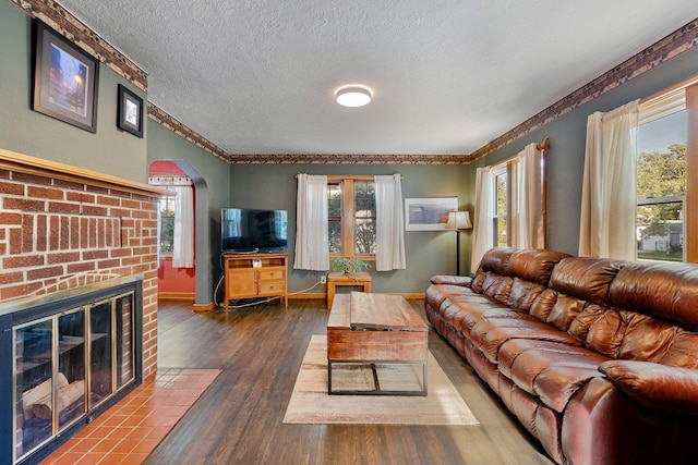 308 4th Ave SW, Austin, MN 55912 - living area with arched walkways, wood finished floors, plenty of natural light, a textured ceiling, and ornamental molding