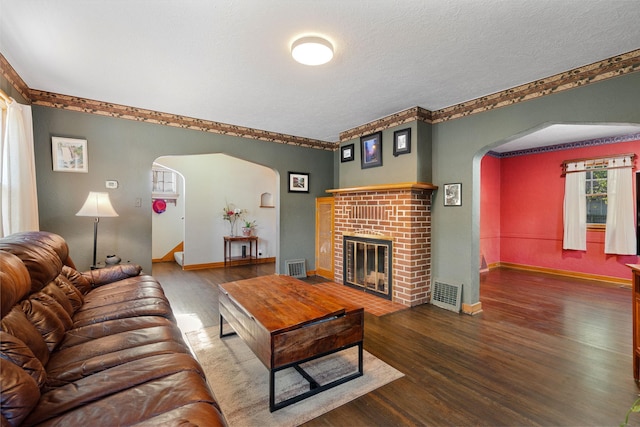 308 4th Ave SW, Austin, MN 55912 - living area featuring arched walkways, wood finished floors, a fireplace, baseboards, and a textured ceiling