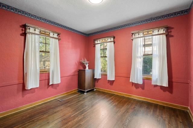 308 4th Ave SW, Austin, MN 55912 - empty room featuring wood finished floors, healthy amount of natural light, baseboards, and a textured ceiling