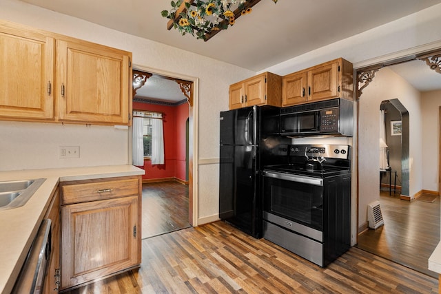 308 4th Ave SW, Austin, MN 55912 - kitchen featuring black appliances, light wood-style flooring, light countertops, arched walkways, and baseboards