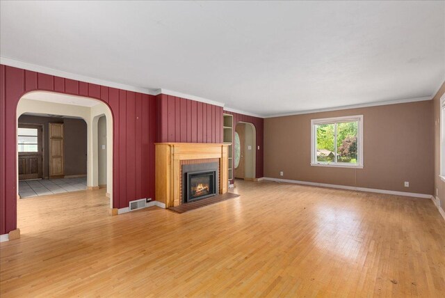 950 Clark St, Hammond, WI 54015 - unfurnished living room featuring arched walkways, ornamental molding, light wood finished floors, a brick fireplace, and baseboards
