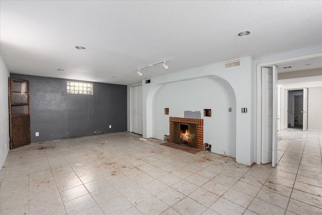 950 Clark St, Hammond, WI 54015 - unfurnished living room with a fireplace, a textured ceiling, and arched walkways