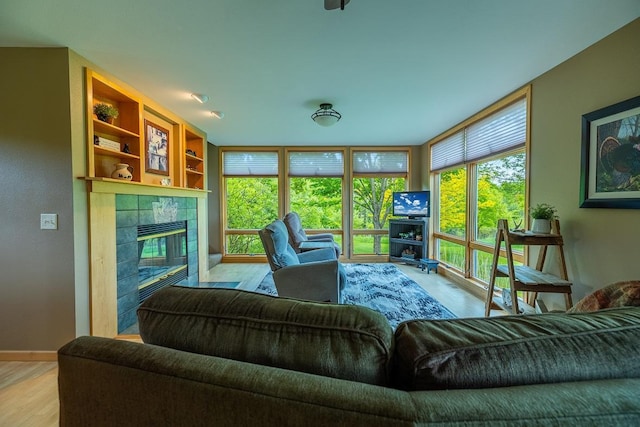 E2221 930th Ave, Stanton Twp, WI 54725 - living area featuring a fireplace, wood finished floors, floor to ceiling windows, and baseboards