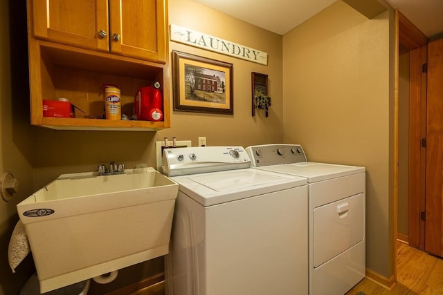 E2221 930th Ave, Stanton Twp, WI 54725 - laundry area featuring cabinet space, washing machine and dryer, and light wood-style floors