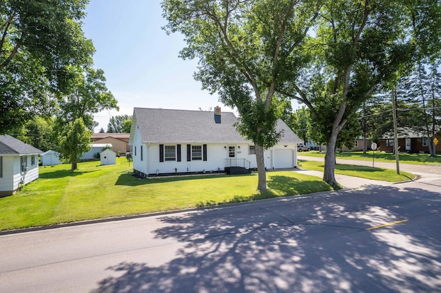 727 Peck St, Fergus Falls, MN 56537 - cape cod house with concrete driveway, an attached garage, a front lawn, a chimney, and a shingled roof