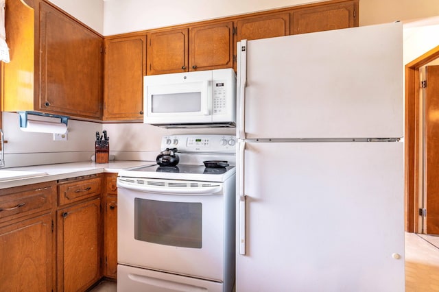 727 Peck St, Fergus Falls, MN 56537 - kitchen featuring white appliances, brown cabinets, and light countertops