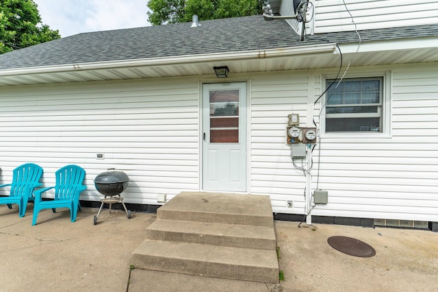 727 Peck St, Fergus Falls, MN 56537 - doorway to property featuring a shingled roof and a patio