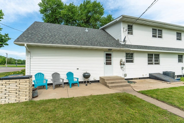 727 Peck St, Fergus Falls, MN 56537 - rear view of property featuring a patio, a shingled roof, and a lawn