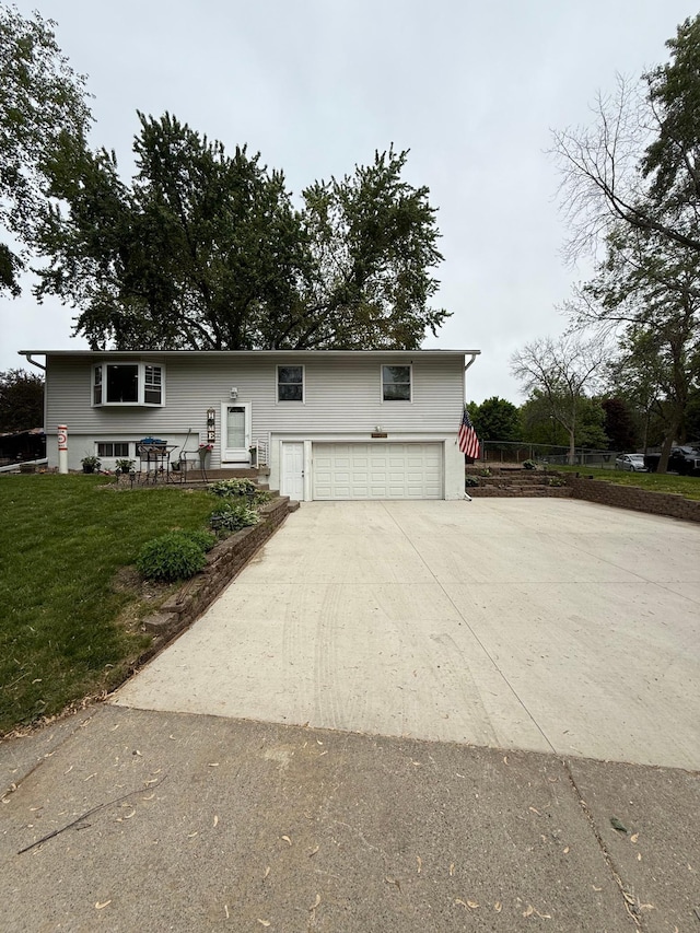 14496 55th St N, Oak Park Heights, MN 55082 - bi-level home featuring concrete driveway, an attached garage, and a front lawn