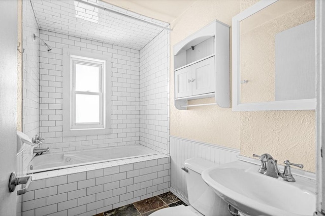 1040 86th Ave W, Duluth, MN 55808 - bathroom featuring a sink, toilet, tiled shower / bath combo, a textured wall, and a wainscoted wall