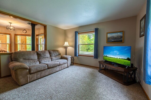 S363 Nicholes Rd, Naples Twp, WI 54755 - carpeted living area with baseboards, a chandelier, and a textured ceiling