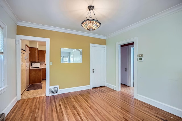 2653 Pierce St NE, Minneapolis, MN 55418 - unfurnished room with crown molding, baseboards, light wood-style floors, and a chandelier