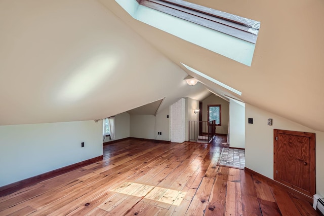 2653 Pierce St NE, Minneapolis, MN 55418 - bonus room featuring a skylight, light wood-style floors, a baseboard heating unit, lofted ceiling, and baseboards