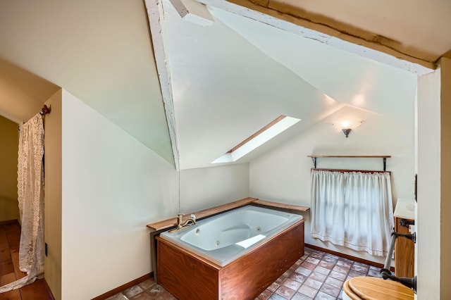 2653 Pierce St NE, Minneapolis, MN 55418 - full bath featuring vaulted ceiling, a skylight, a whirlpool tub, toilet, and baseboards