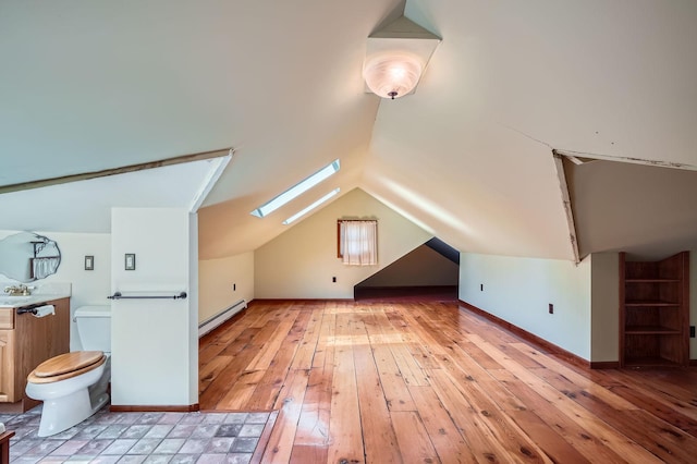 2653 Pierce St NE, Minneapolis, MN 55418 - additional living space featuring a baseboard heating unit, a skylight, light wood finished floors, lofted ceiling, and baseboards