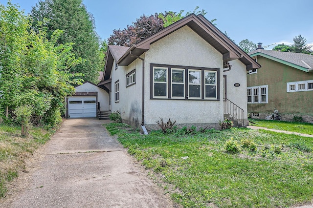 2653 Pierce St NE, Minneapolis, MN 55418 - bungalow-style house with driveway, stucco siding, an outbuilding, and entry steps