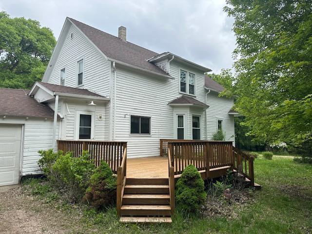 77729 330th St, Prior Twp, MN 56278 - back of house with a chimney, a deck, an attached garage, and roof with shingles