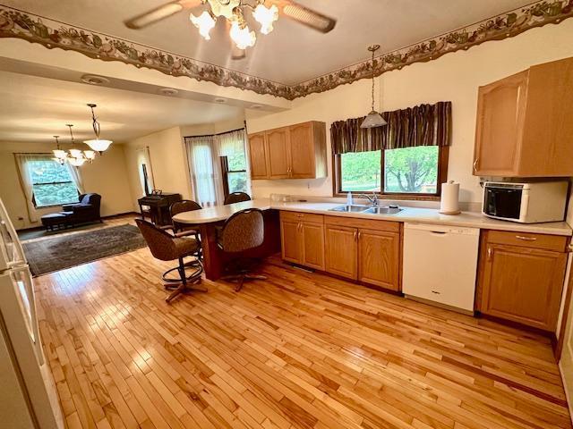 77729 330th St, Prior Twp, MN 56278 - kitchen with white dishwasher, a chandelier, light wood-style flooring, and light countertops