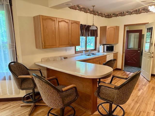 77729 330th St, Prior Twp, MN 56278 - kitchen featuring a breakfast bar, light countertops, stainless steel microwave, and a sink